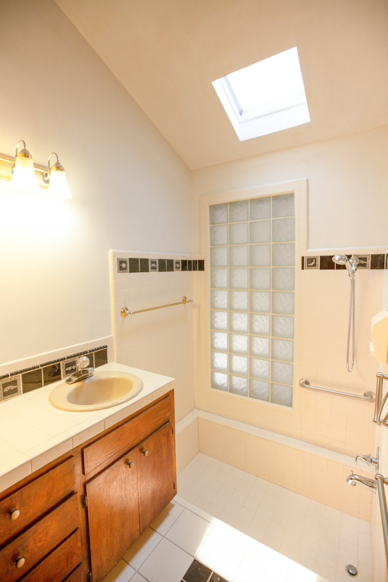 1970s bathroom with dated tile and vanity