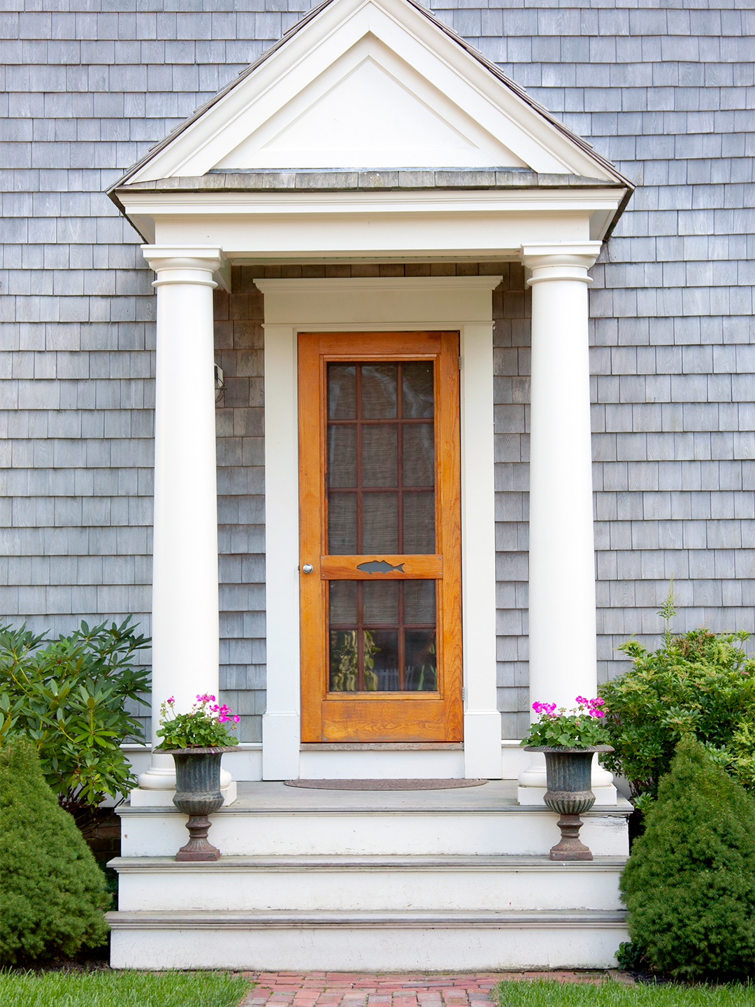 shingled home exterior with natural wood door