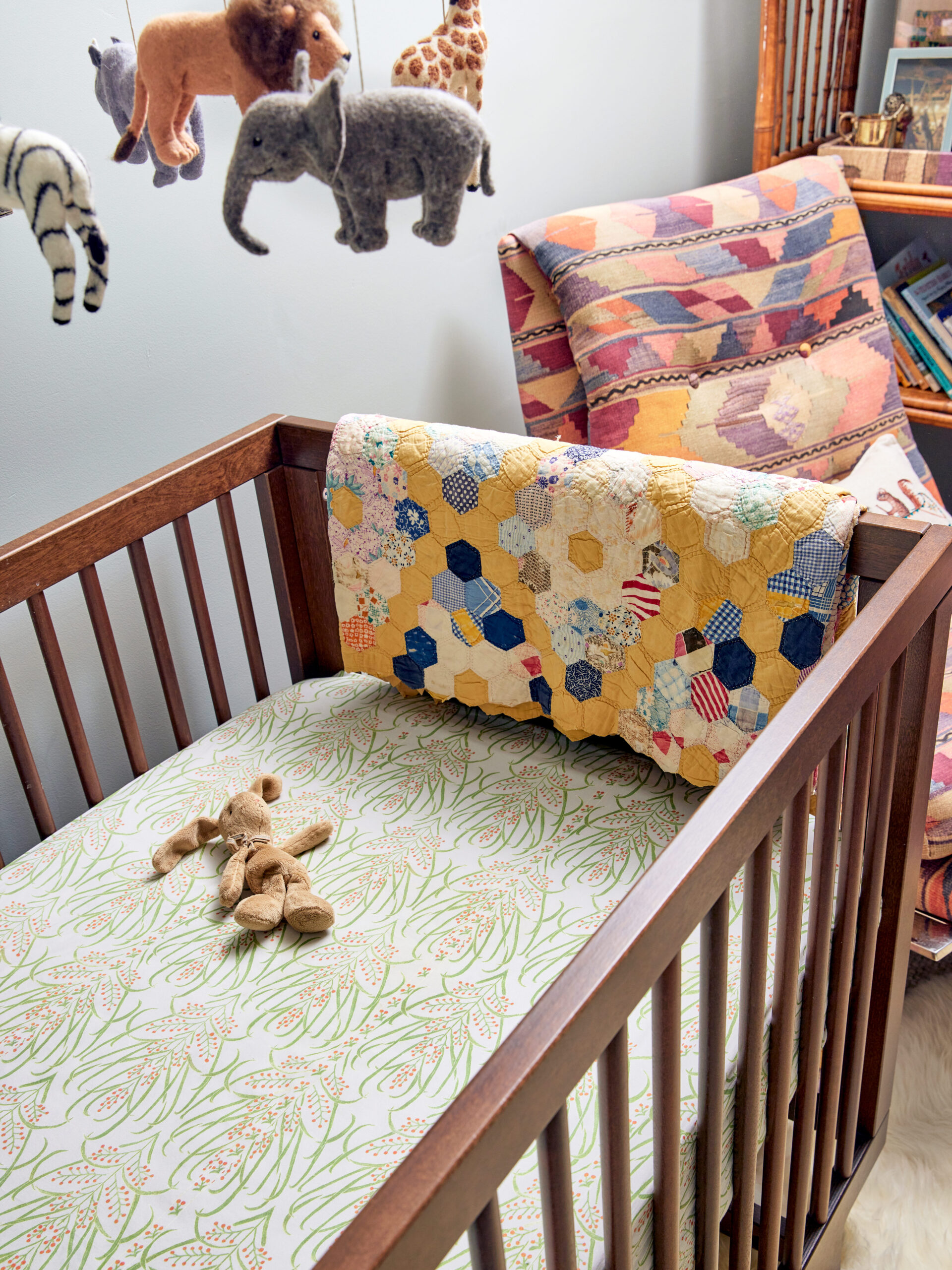 vintage colorful quilt hanging on wood crib