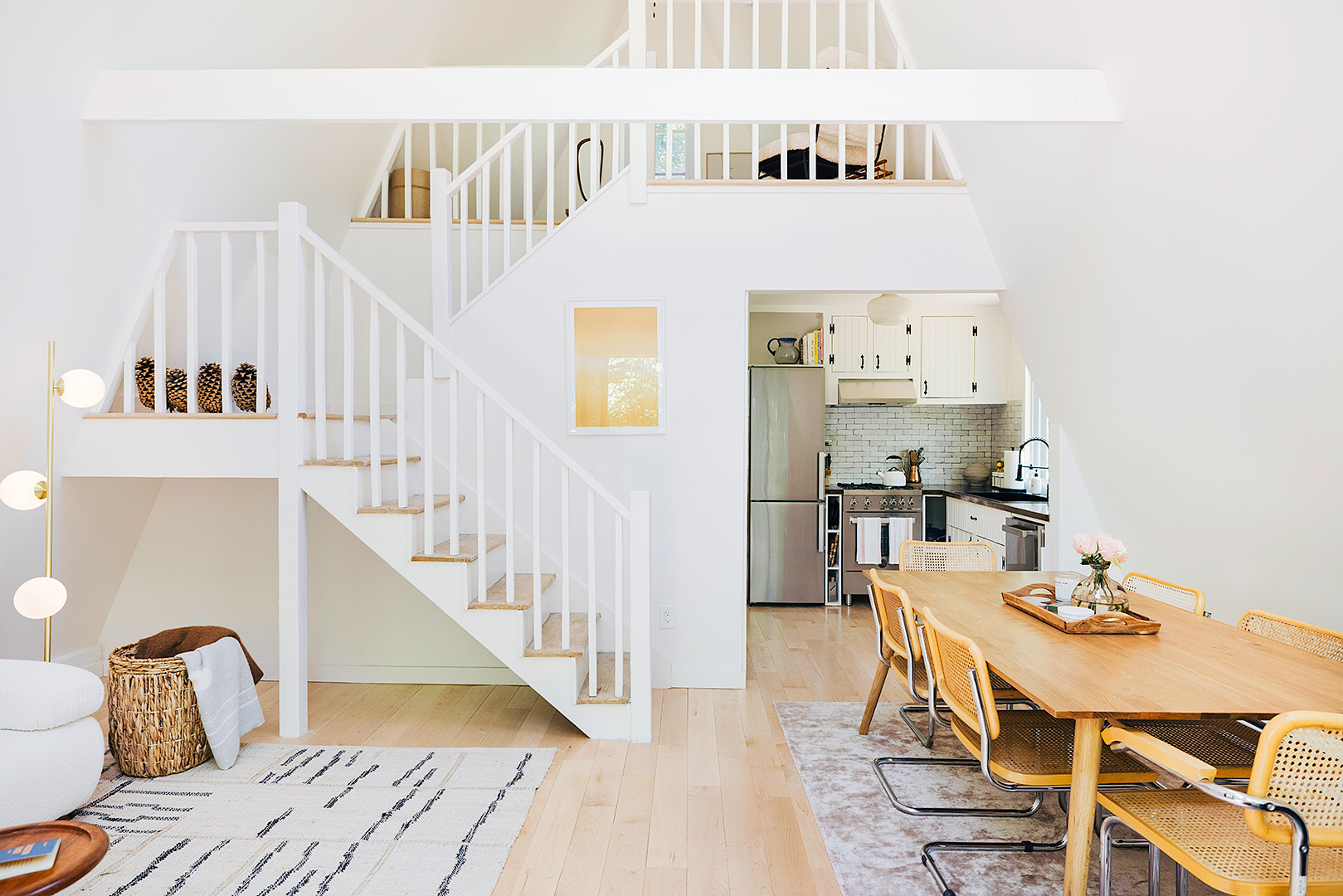 White living room and dining room wide angle shot inclduing staircase to loft