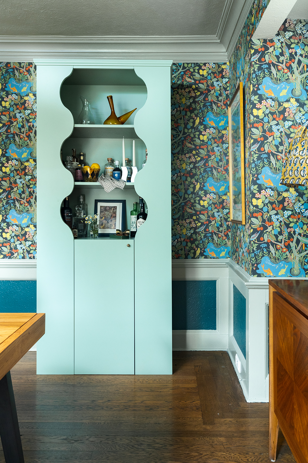 curvy mint green bookcase in green botanical dining room