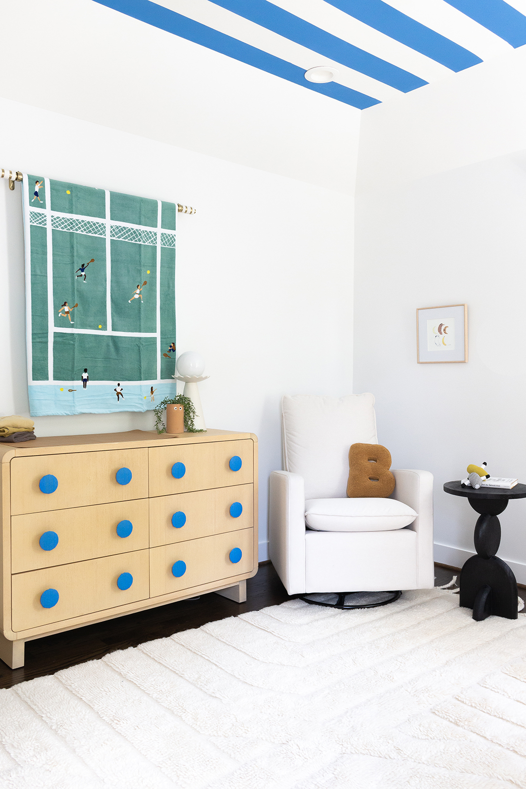 tennis towel hanging above dresser with blue knobs