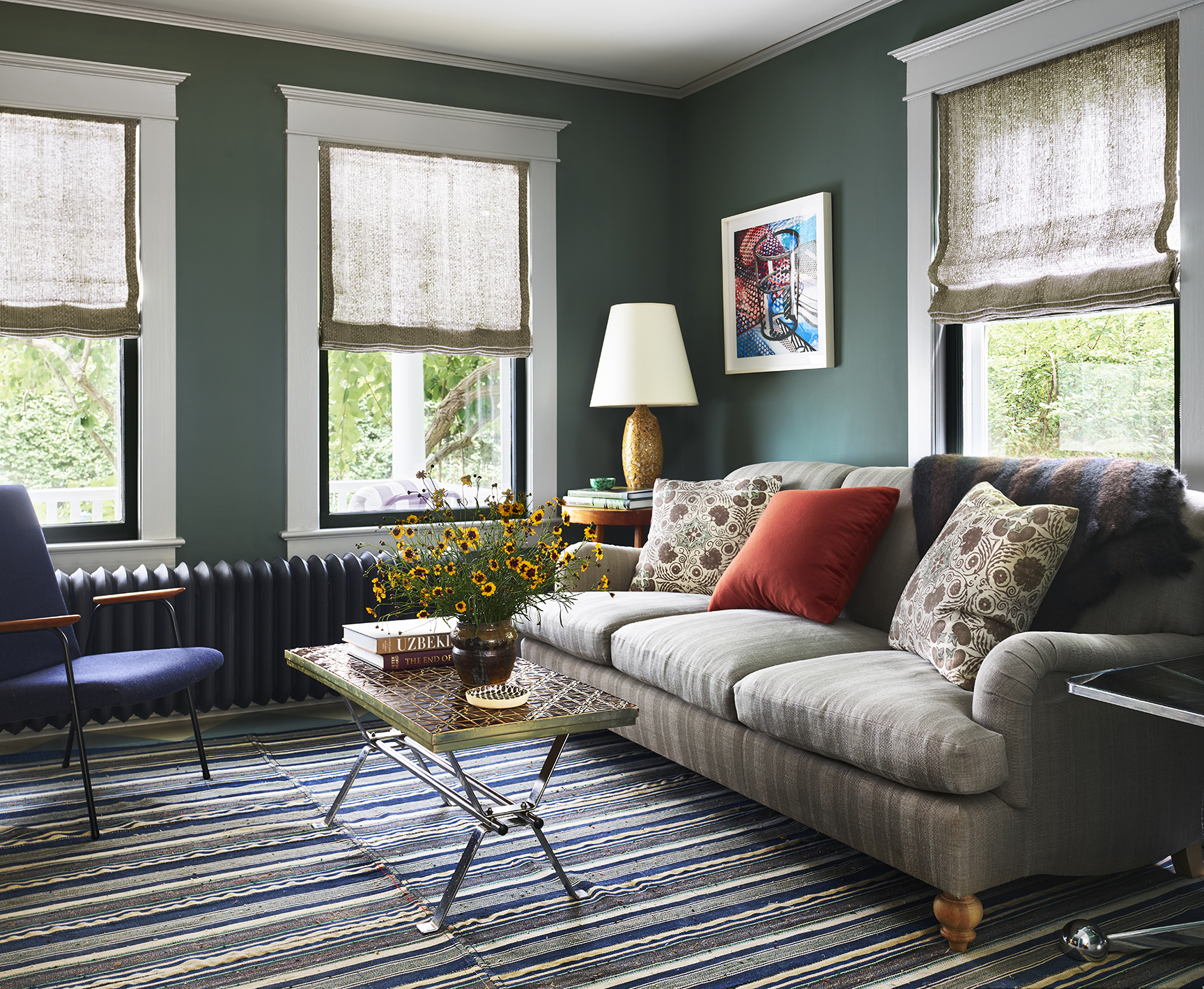 green living room with striped sofa and rug