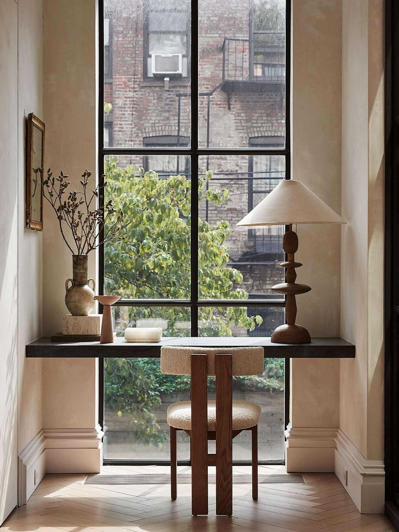 Desk facing a window and a boucle chair