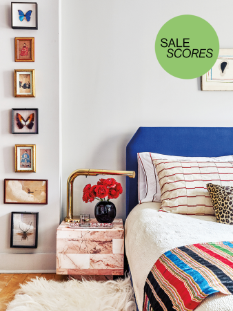 bedroom with blue headboard and picture frames on wall