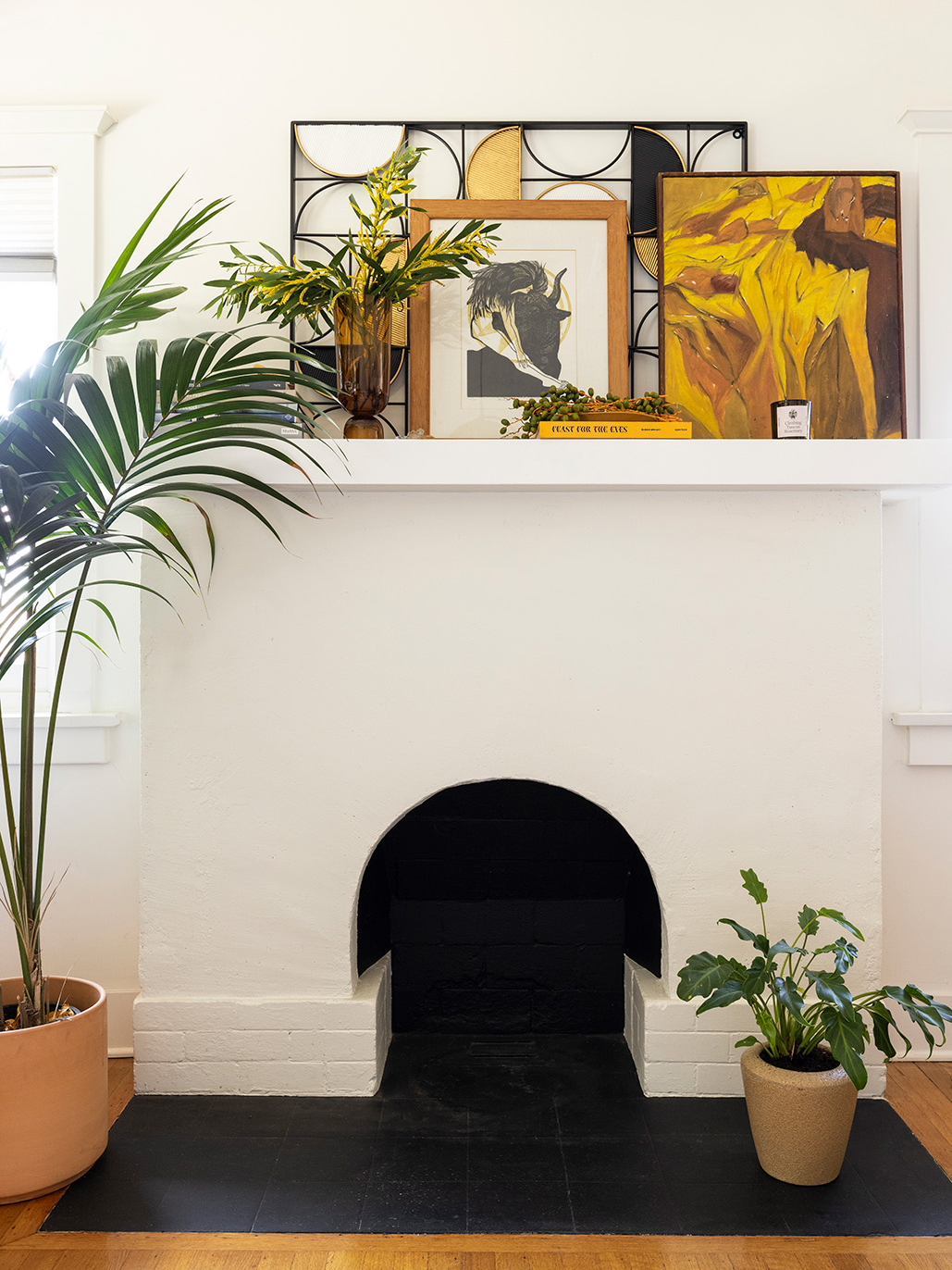 white fireplace with picture frames on mantle