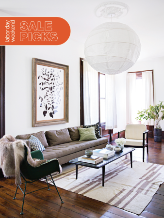 Living room with white paper pendant hanging from ceiling, dark hardwood floors covered with striped flatweave rug