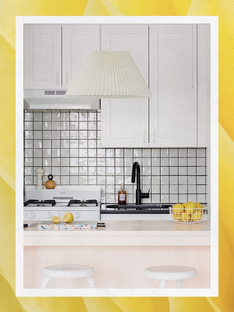 pink kitchen island with white cabinets and peel-and-stick backsplash