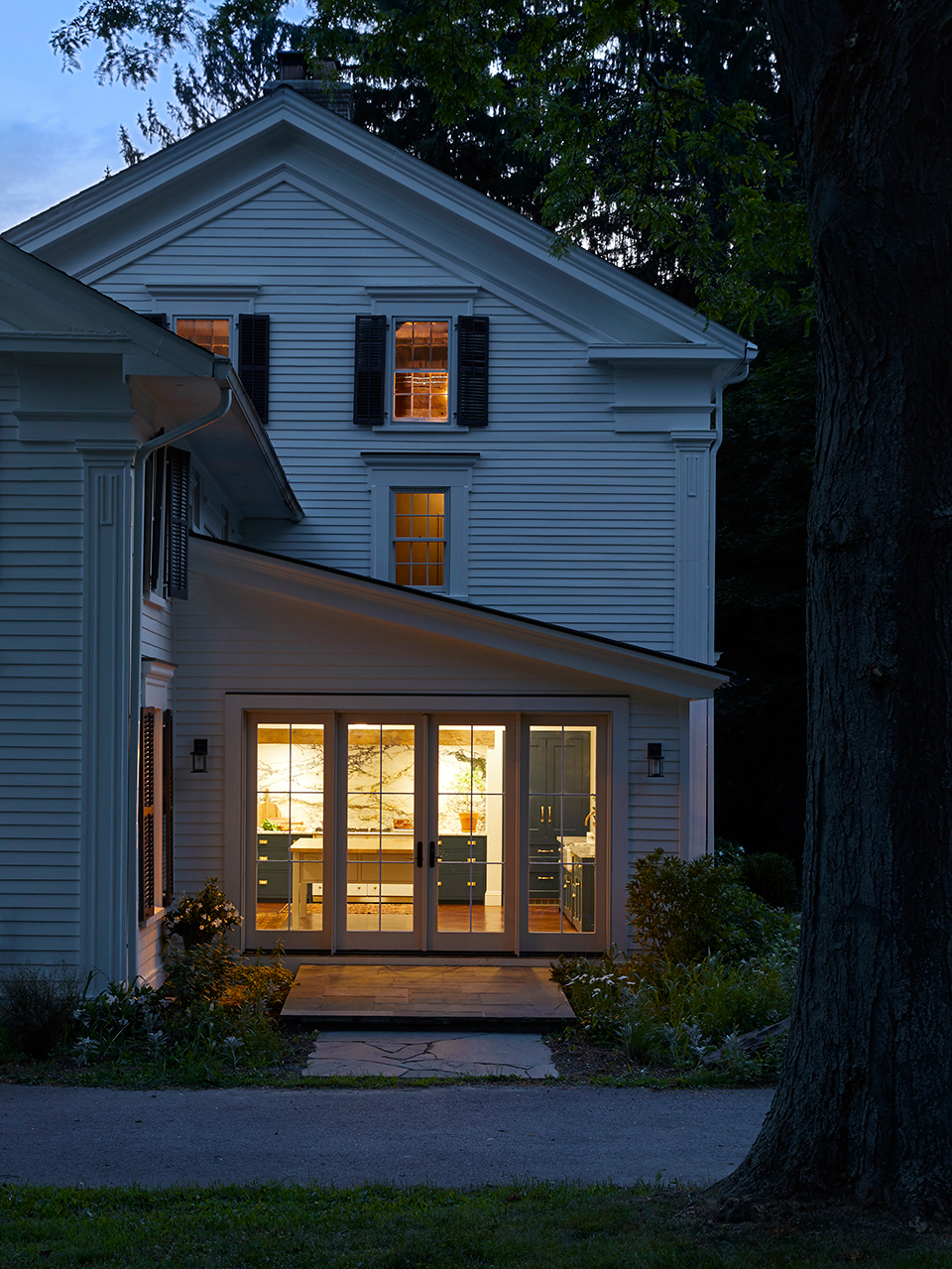 outside looking into lit-up farmhouse