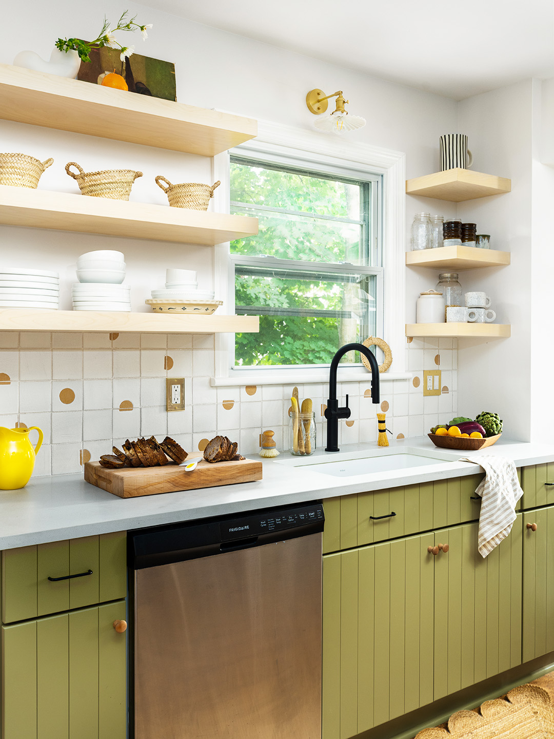 green paneled kitchen cabinets and floating shelves