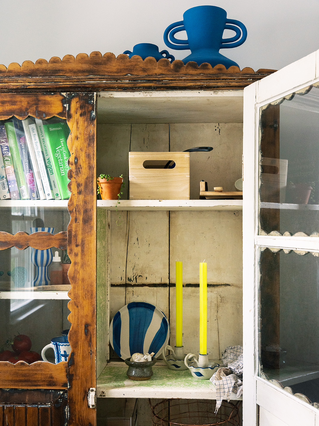 antique hutch with neon yellow candlesticks inside