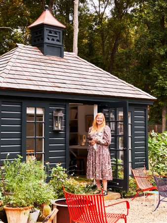 woman in dress standing outside black backyard studio