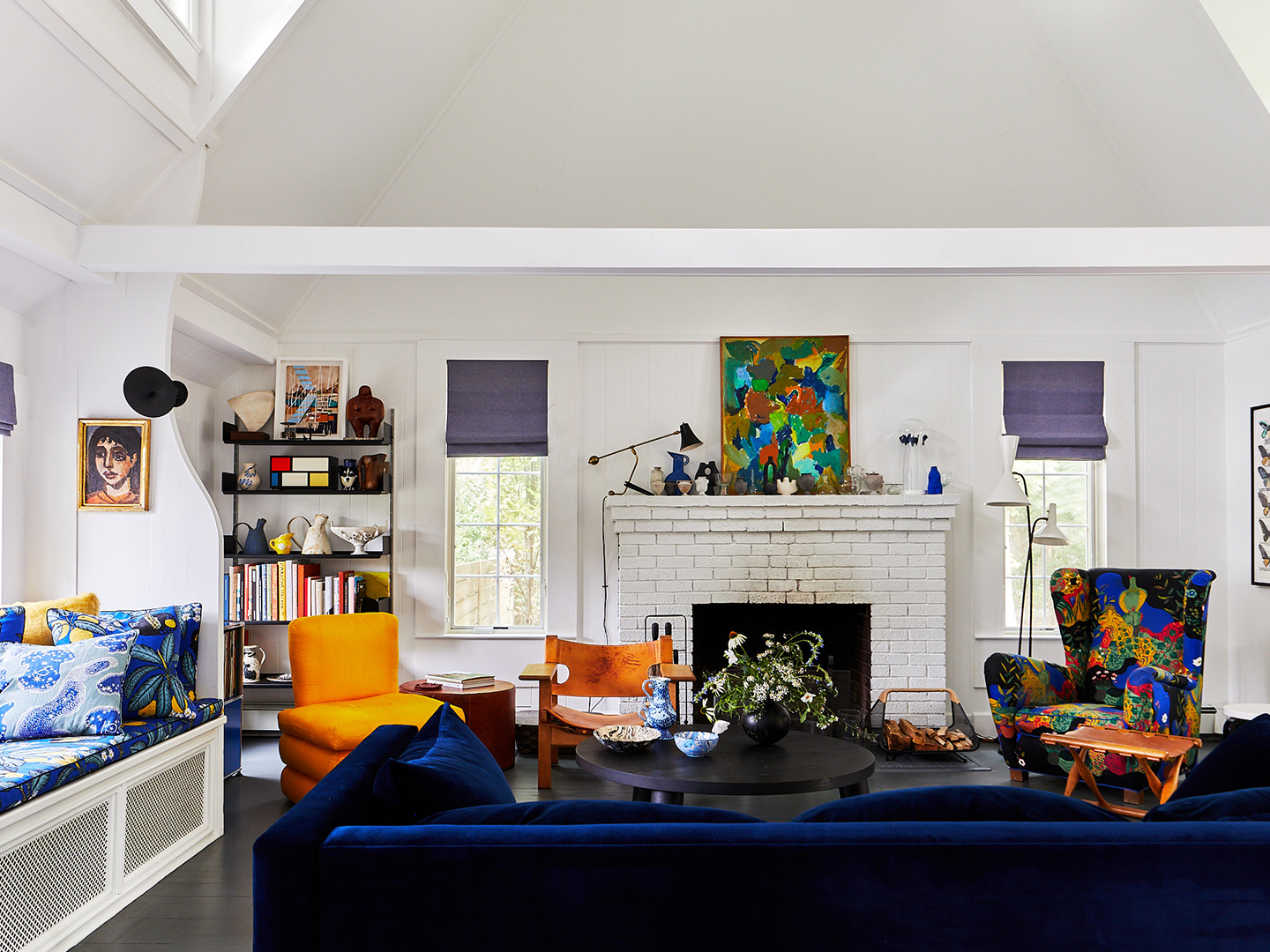 navy sofa and patterned chair in front of fireplace