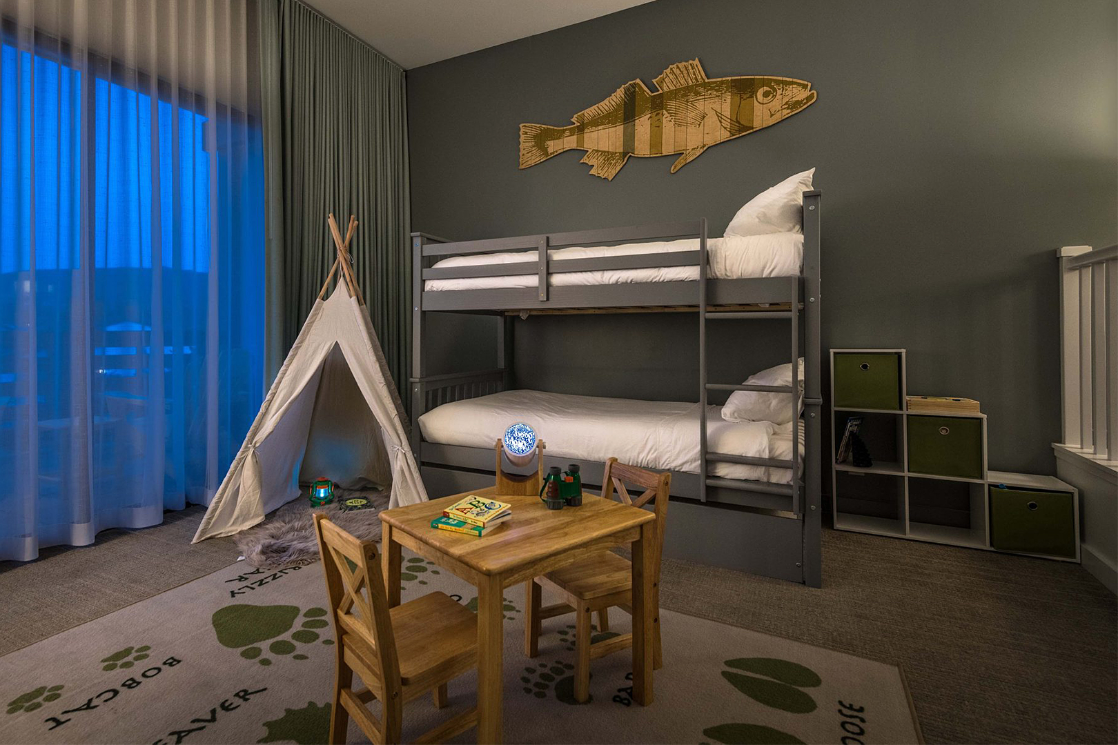 hotel room with bunk beds, tent, and kids table
