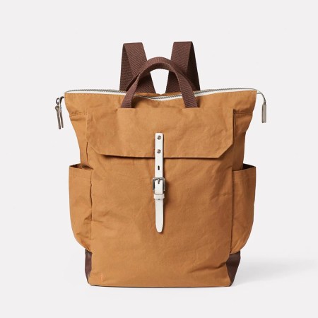  Brown cotton and leather backpack against a white background.