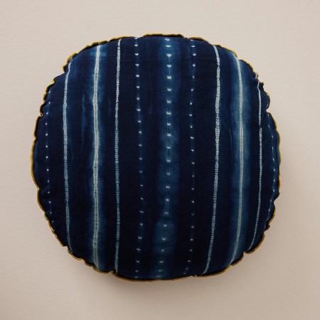  Striped midnight blue floor pillow against a cream background.