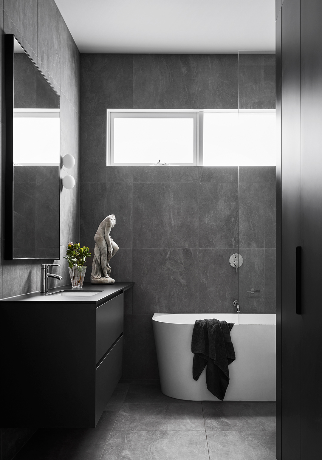 dark gray bathroom with tiled walls and floor