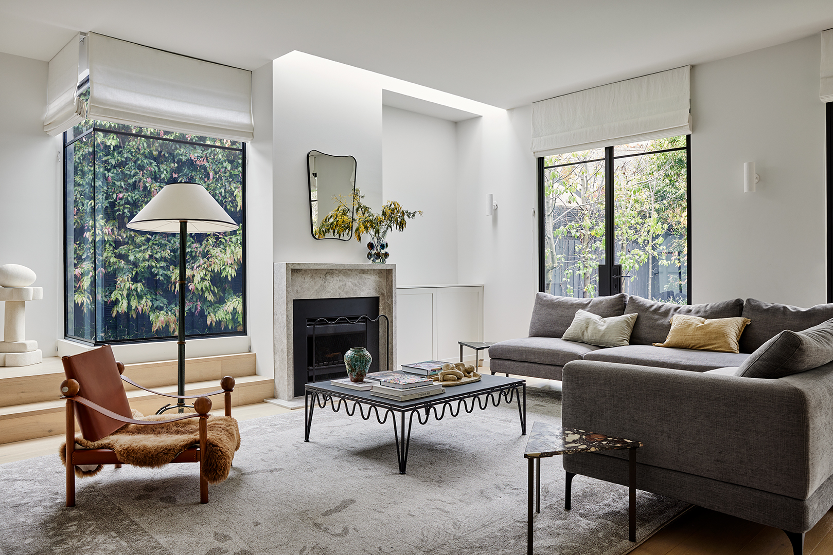 Wider shot of living room with fireplace at center