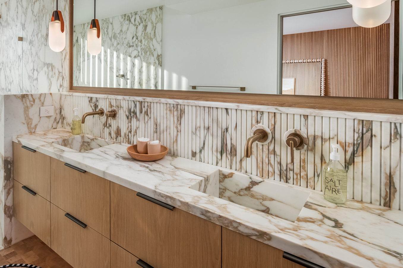 long fluted stone vanity backsplash