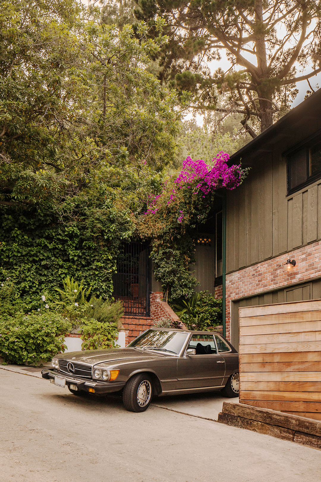 car parked in front of hillside home