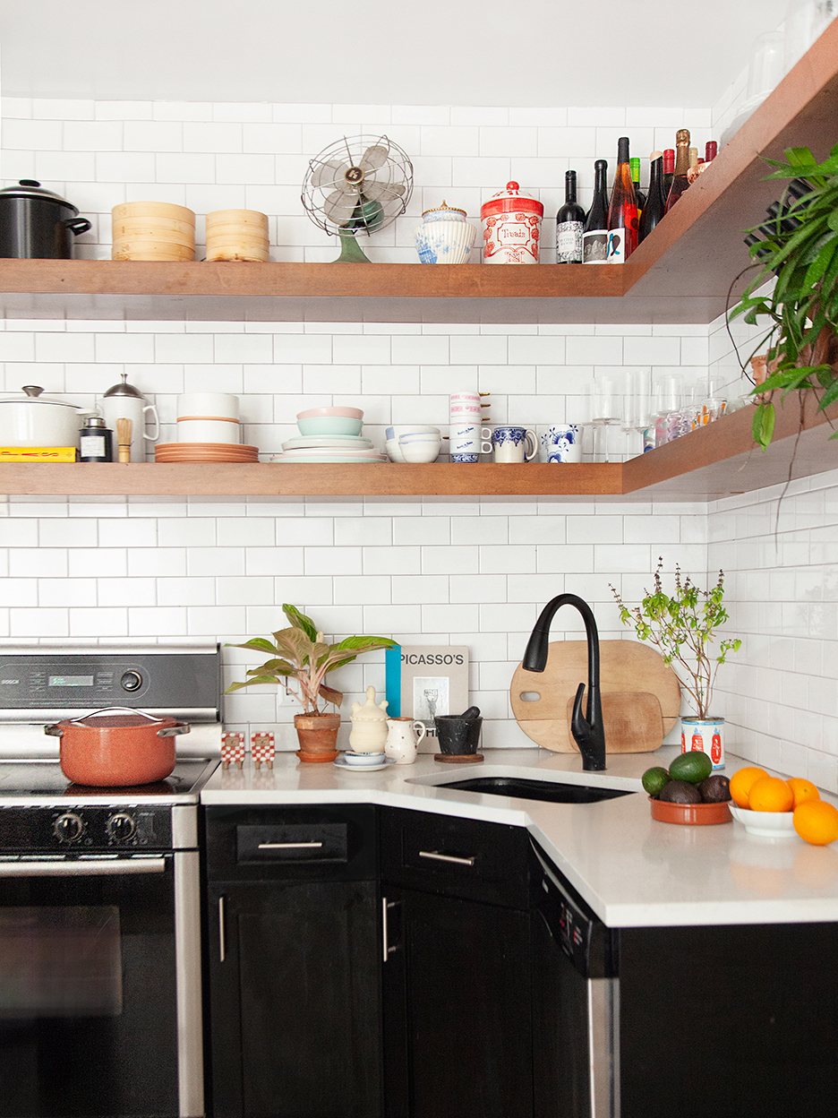 Kitchen with black lower cabinets and open shelving