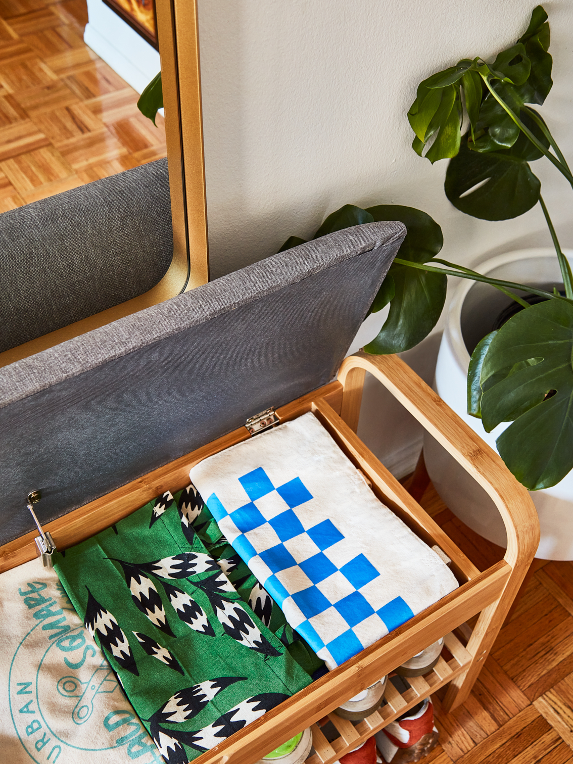 Up top shot of upholstered bamboo bench open with canvas tote bags folded neatly in a row