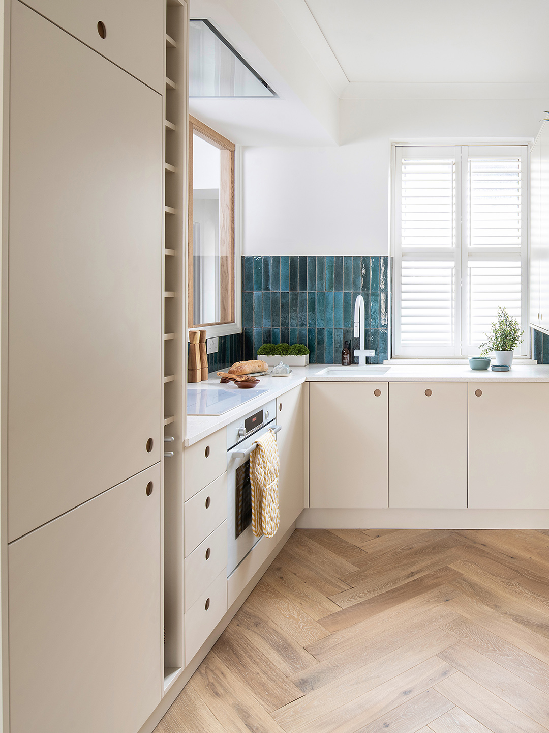 small cream-colored kitchen with turquoise tile