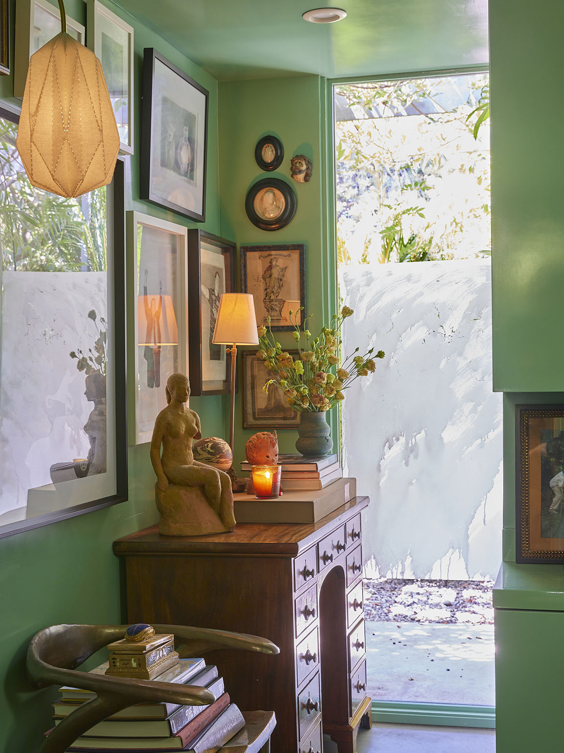 gallery wall above dresser in green bathroom