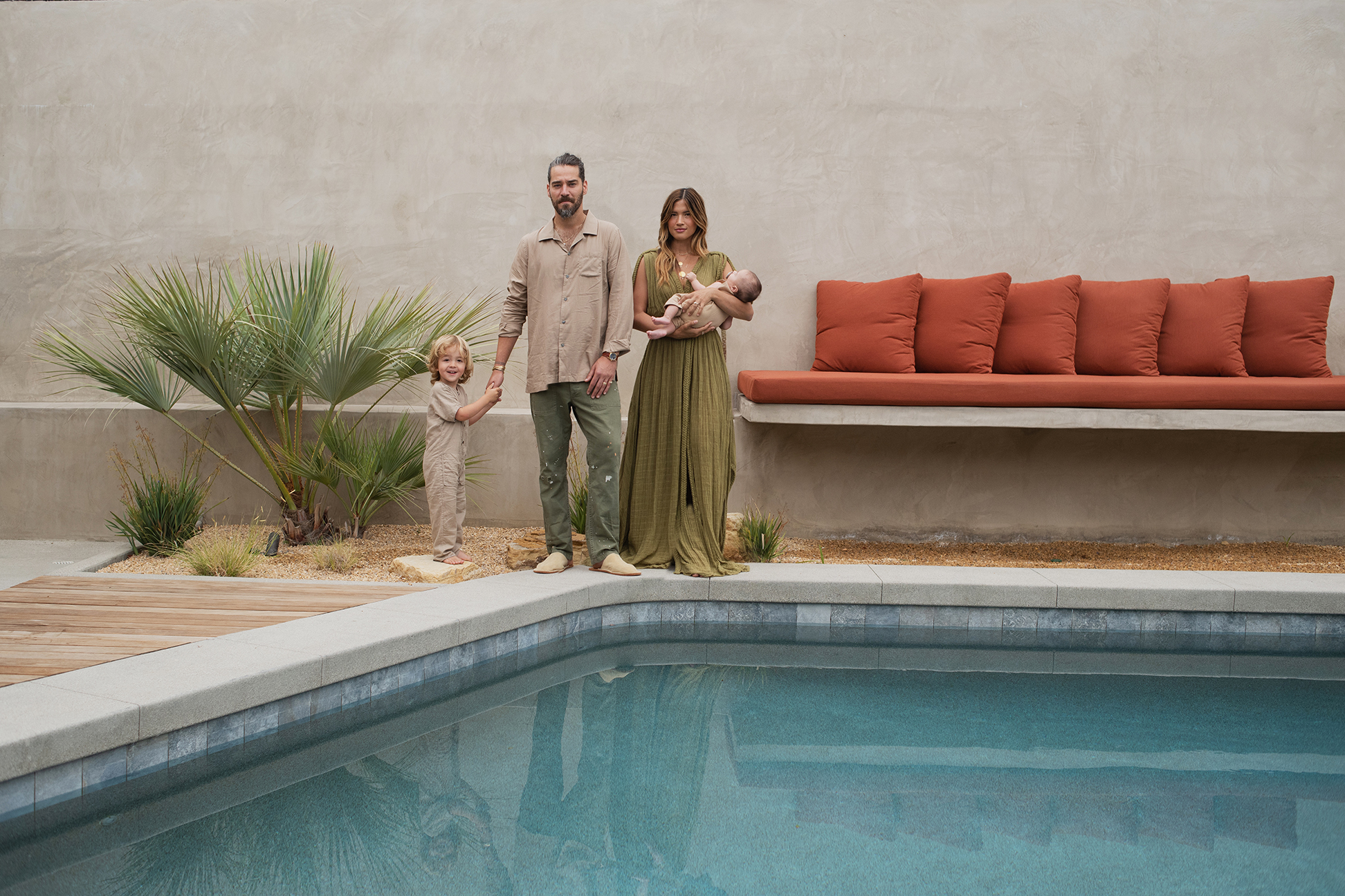 Couple with children standing near pool