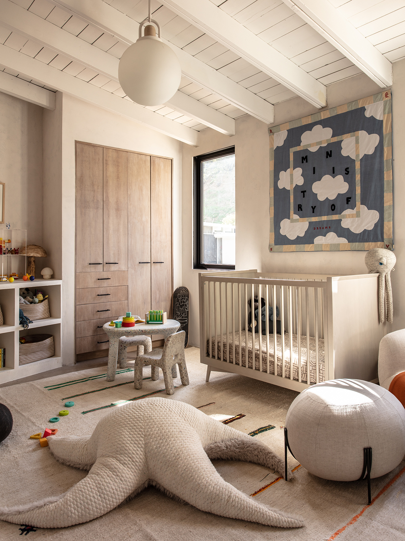 Child's room with quilt hung above crib