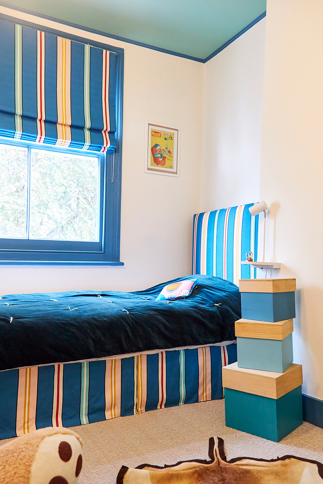 kid's room with navy striped upholstered bed frame