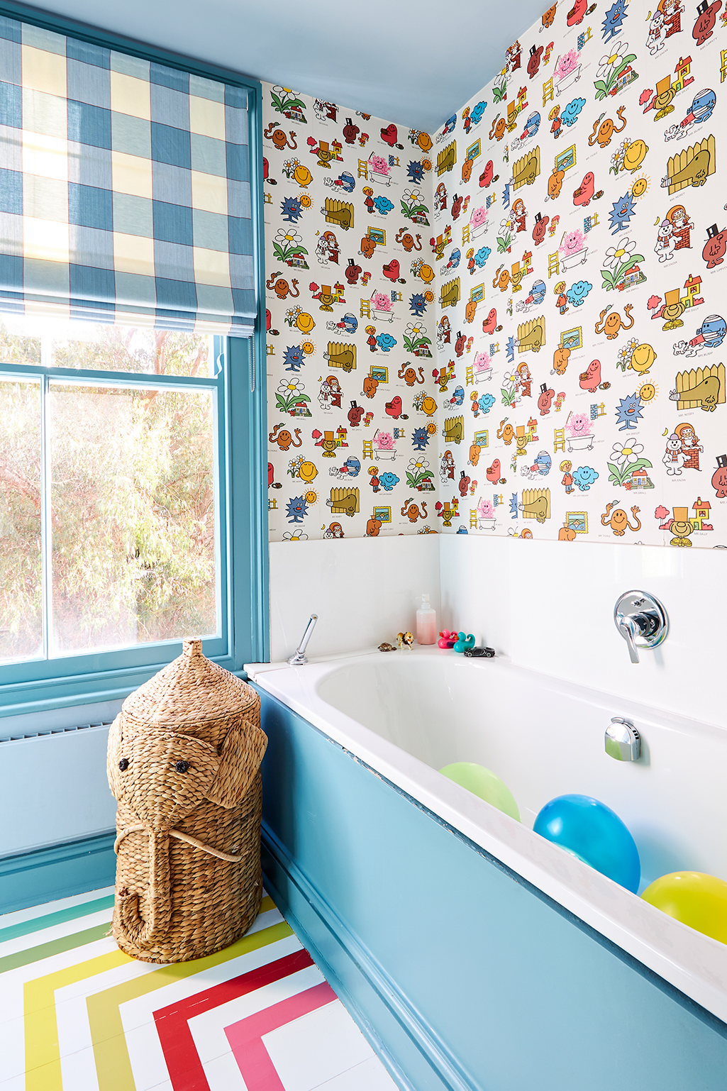 kids' bath with Mr. Men's wallpaper and rainbow striped floor