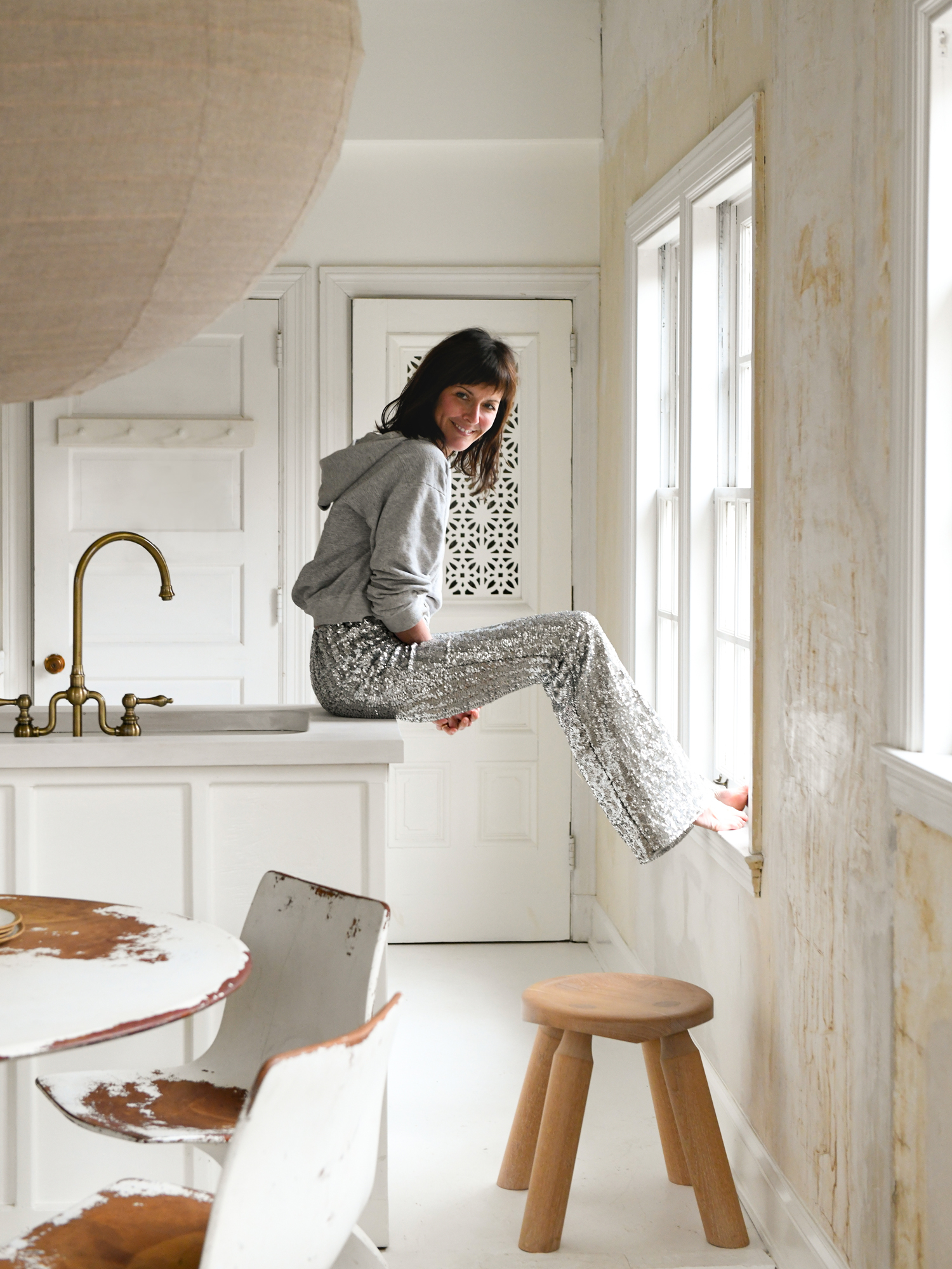 Leanne Ford sitting on her countertop wearing sequin pants