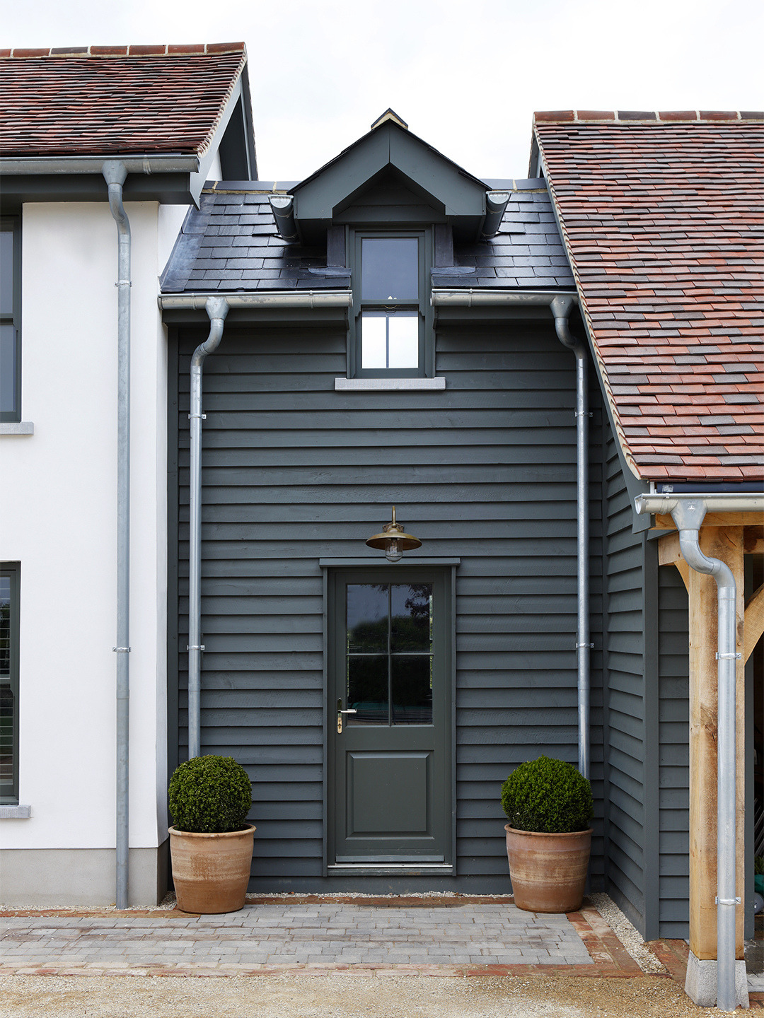 small green house attached to white house