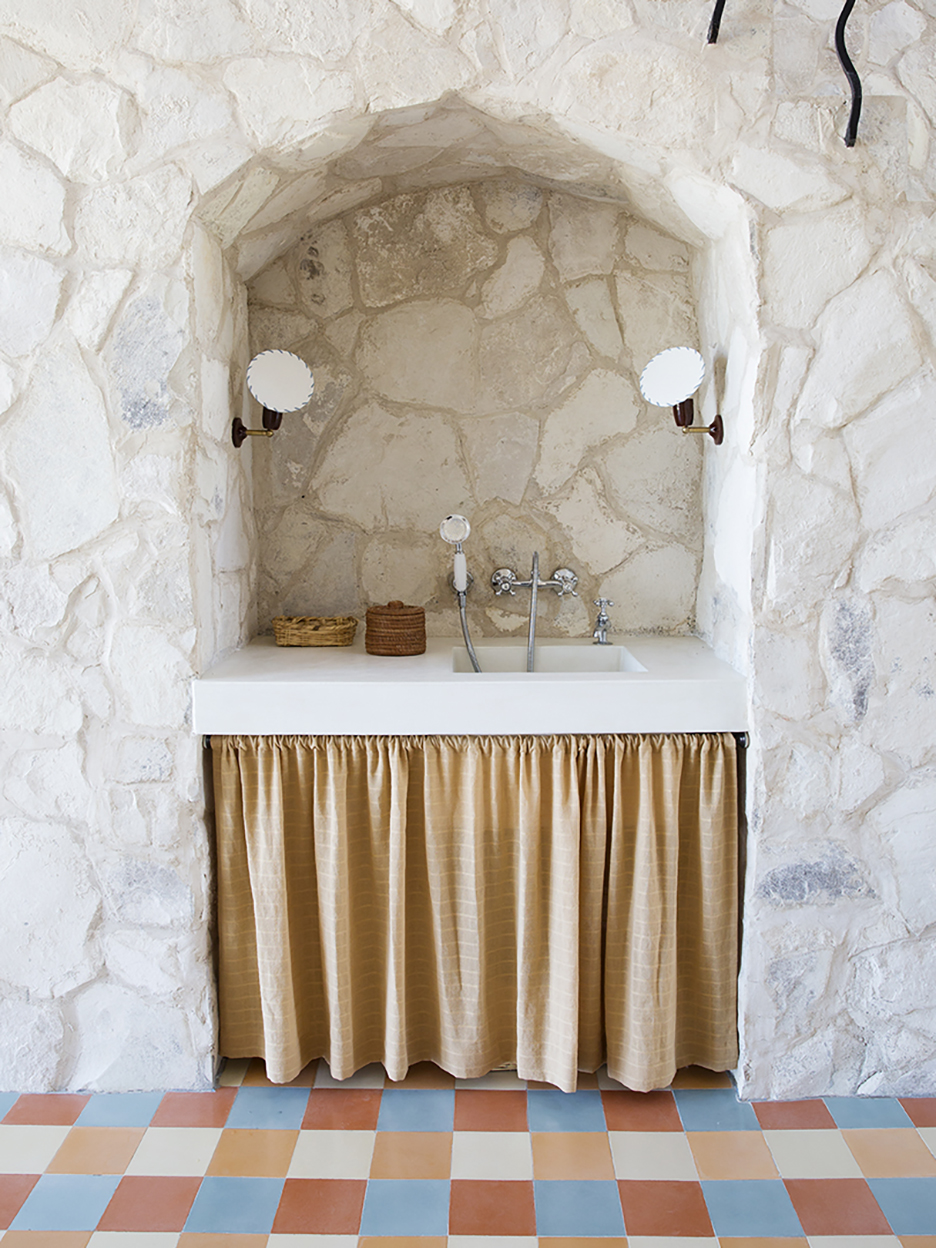 sink nook in stone wall with fabric skirt