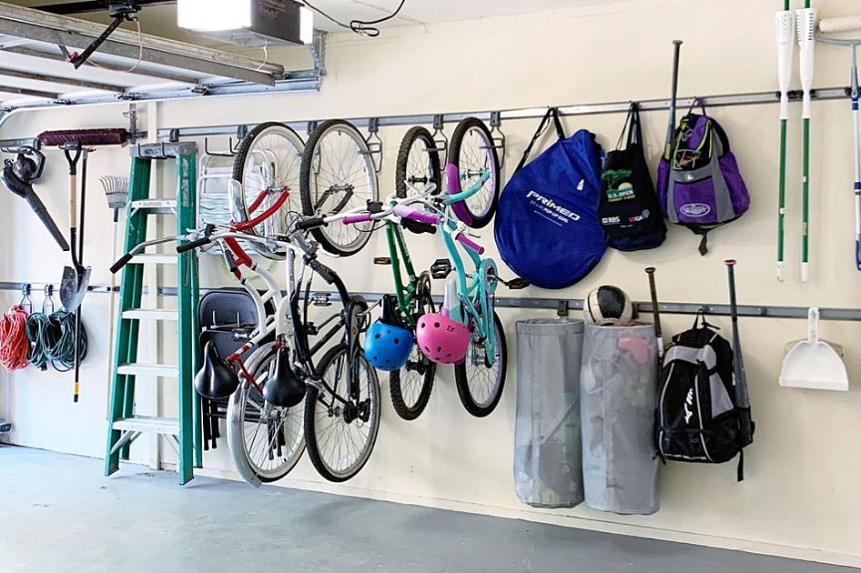 bikes and brooms mounted on garage wall