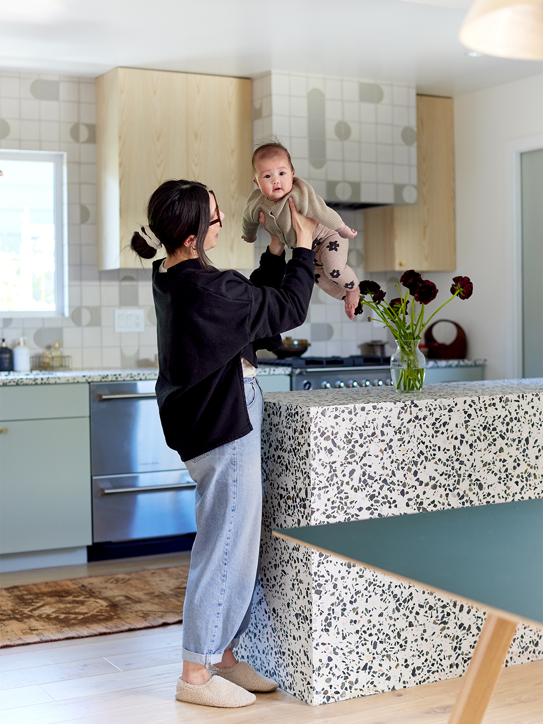 woman holding baby in kitchen