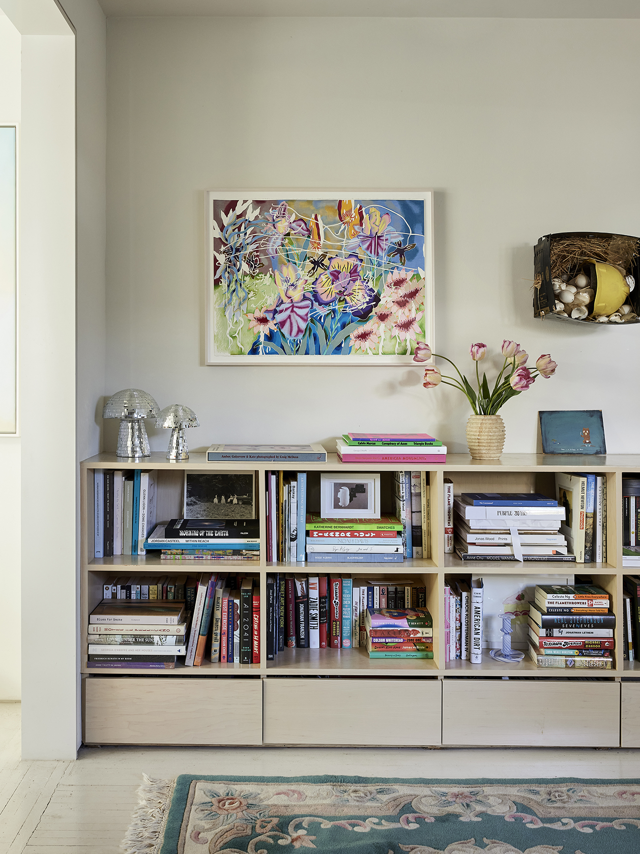 Bookshelf with art hanging above it