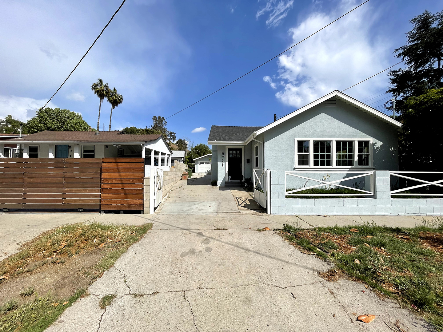 blue house with concrete driveway