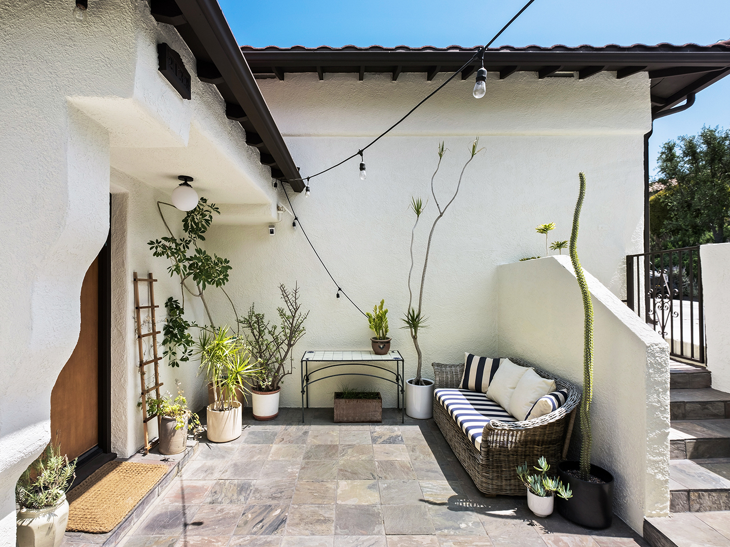 white house with plant filled patio