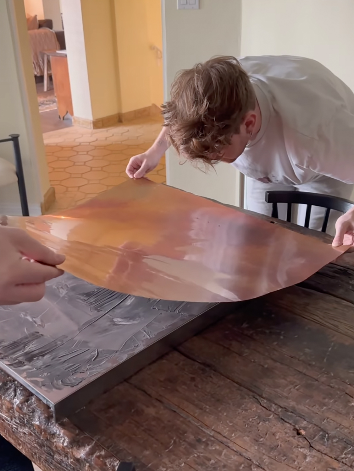 man laying down copper sheet