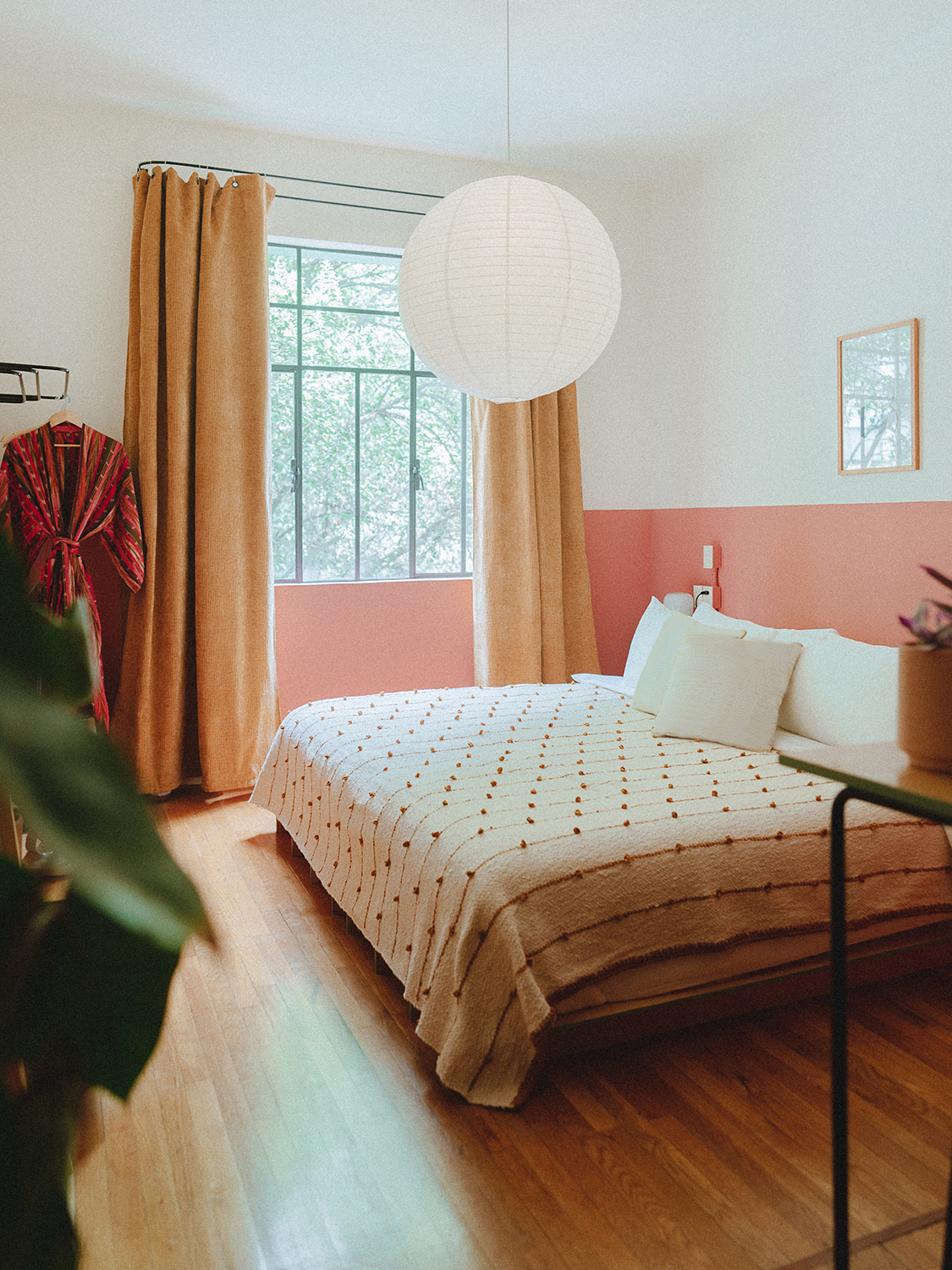 Half painted pink walls and a bed in a guest room