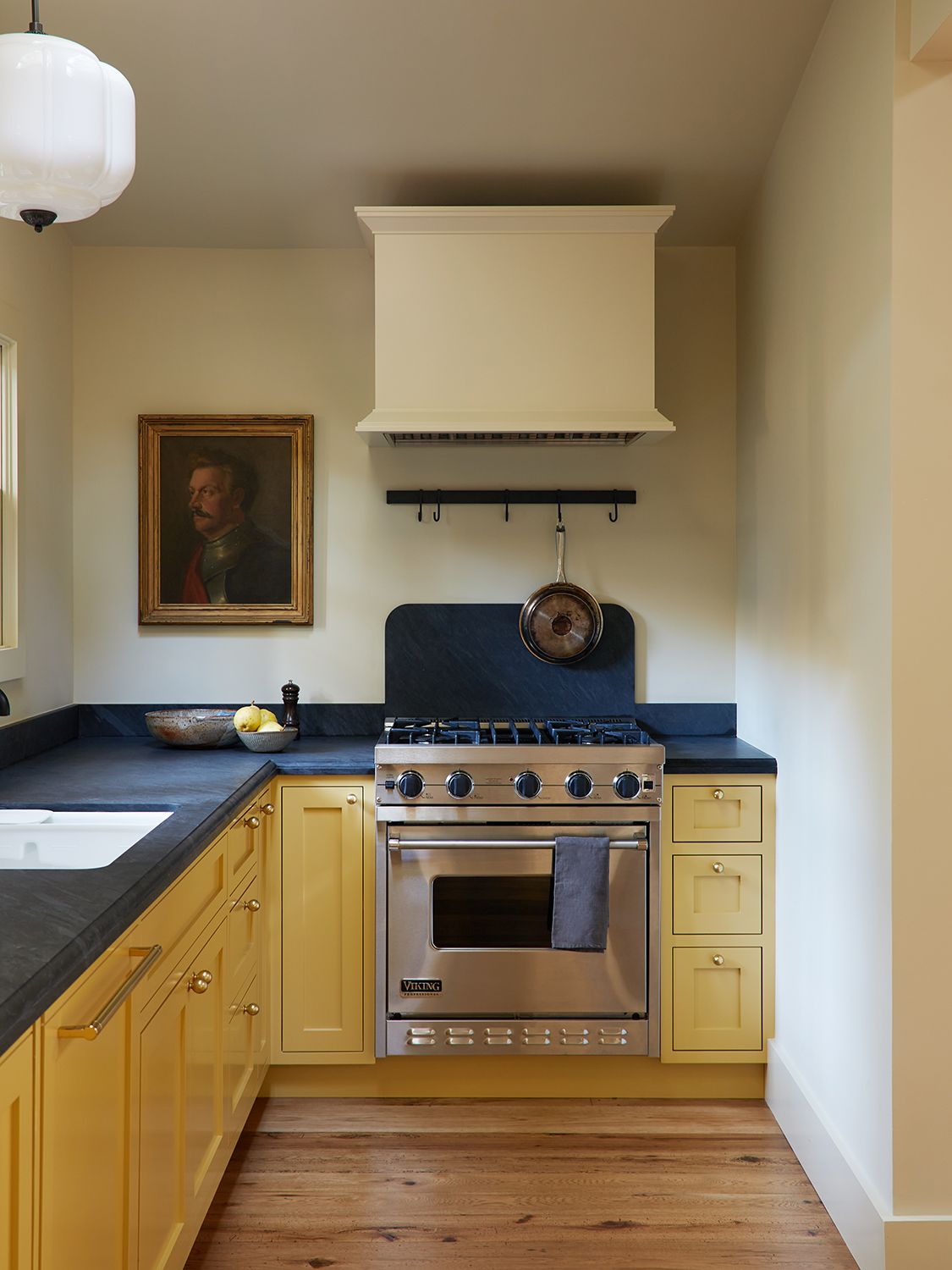 Yellow kitchen cabinets with dark stone countertop