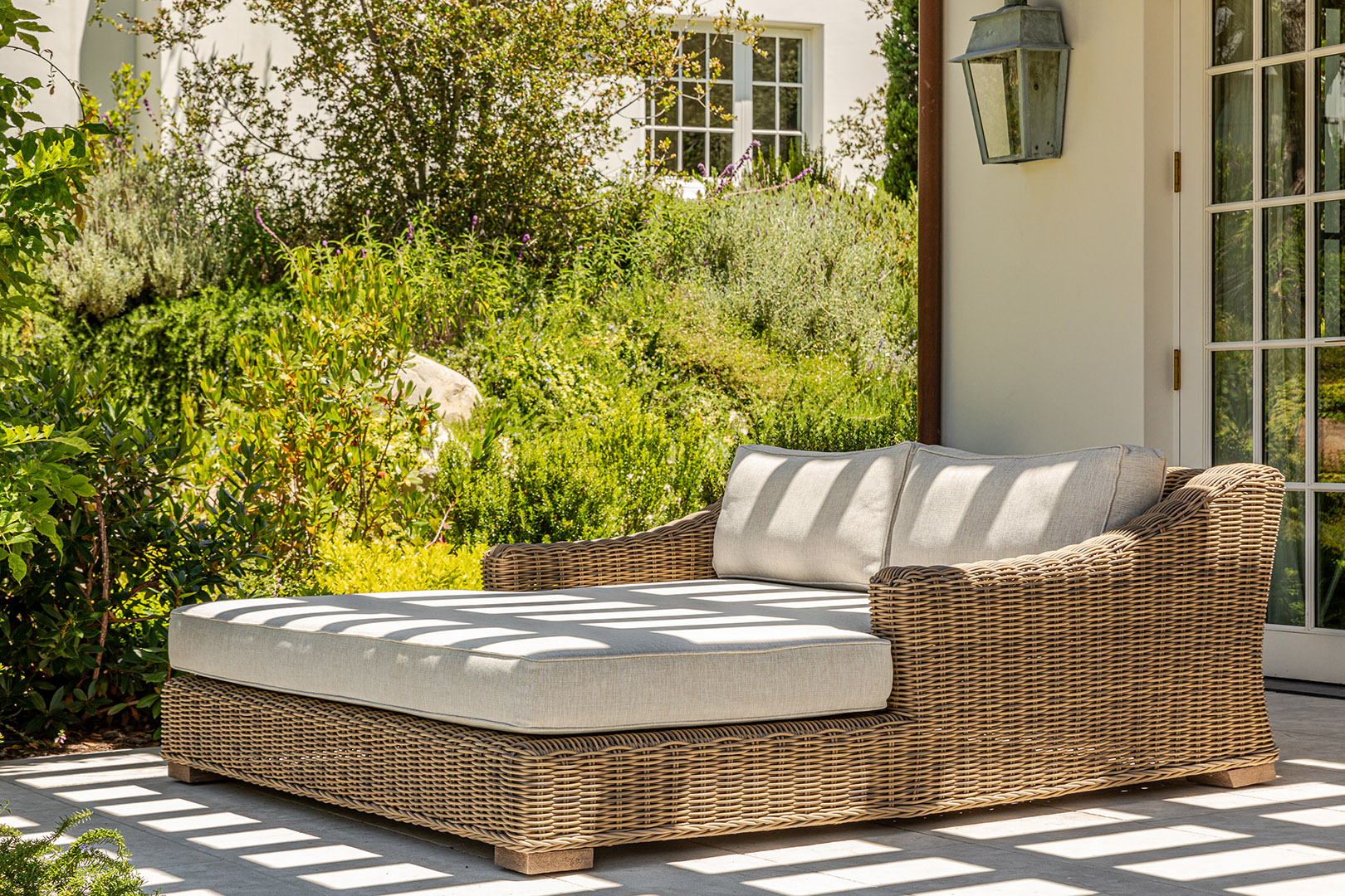 double wicker lounger under pergola