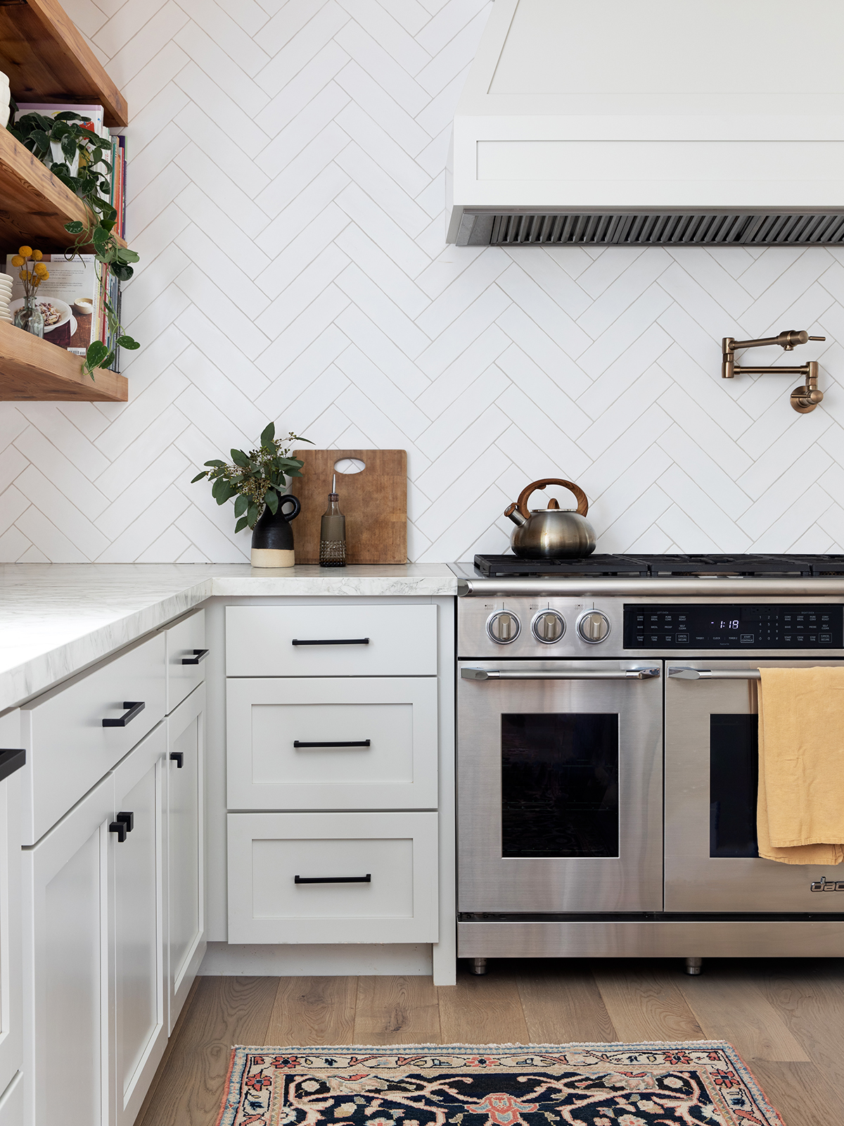 kitchen stovetop area with herringbone backsplash