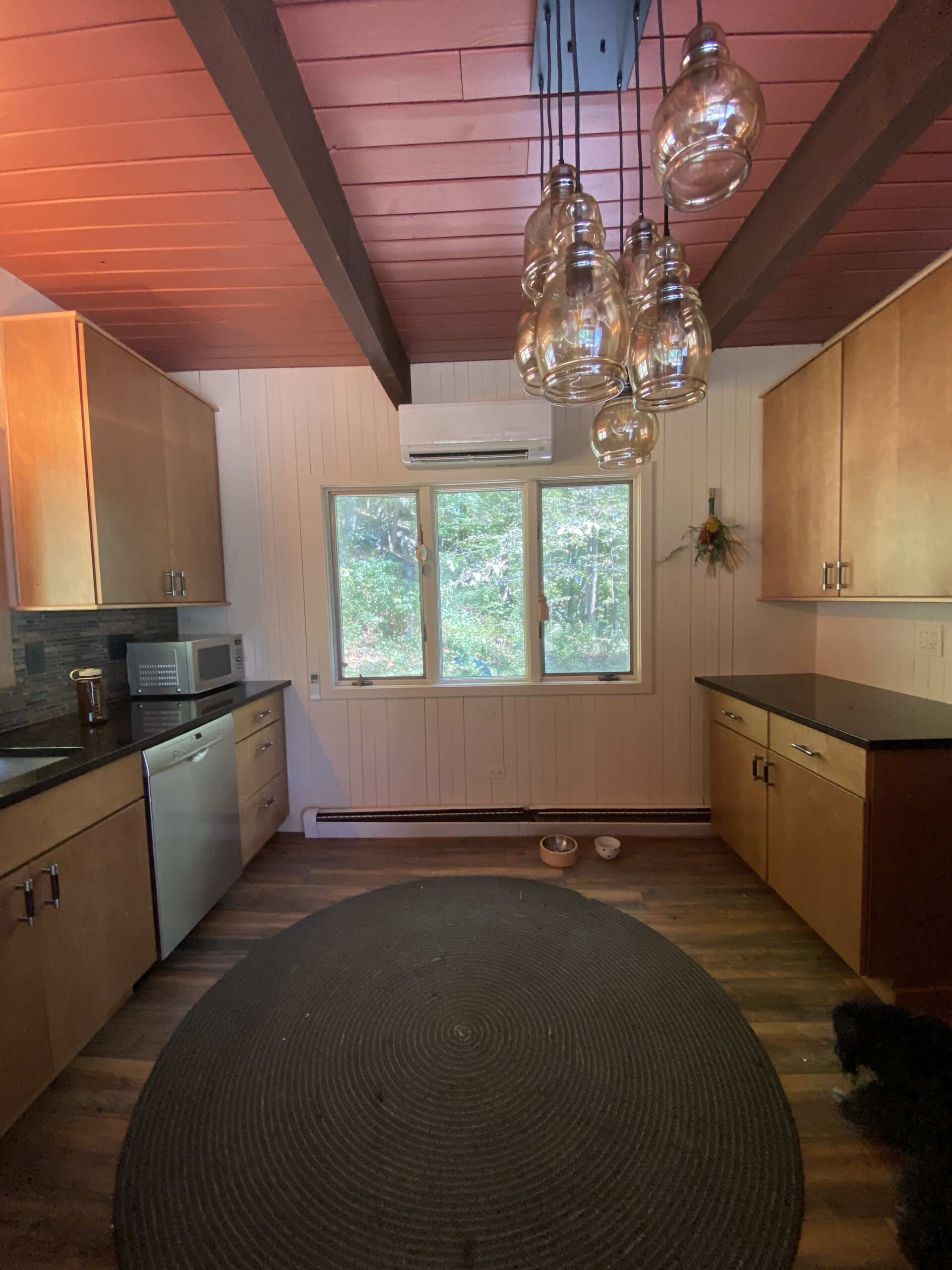 Before photos of a kitchen with wood cabinets and a chandelier