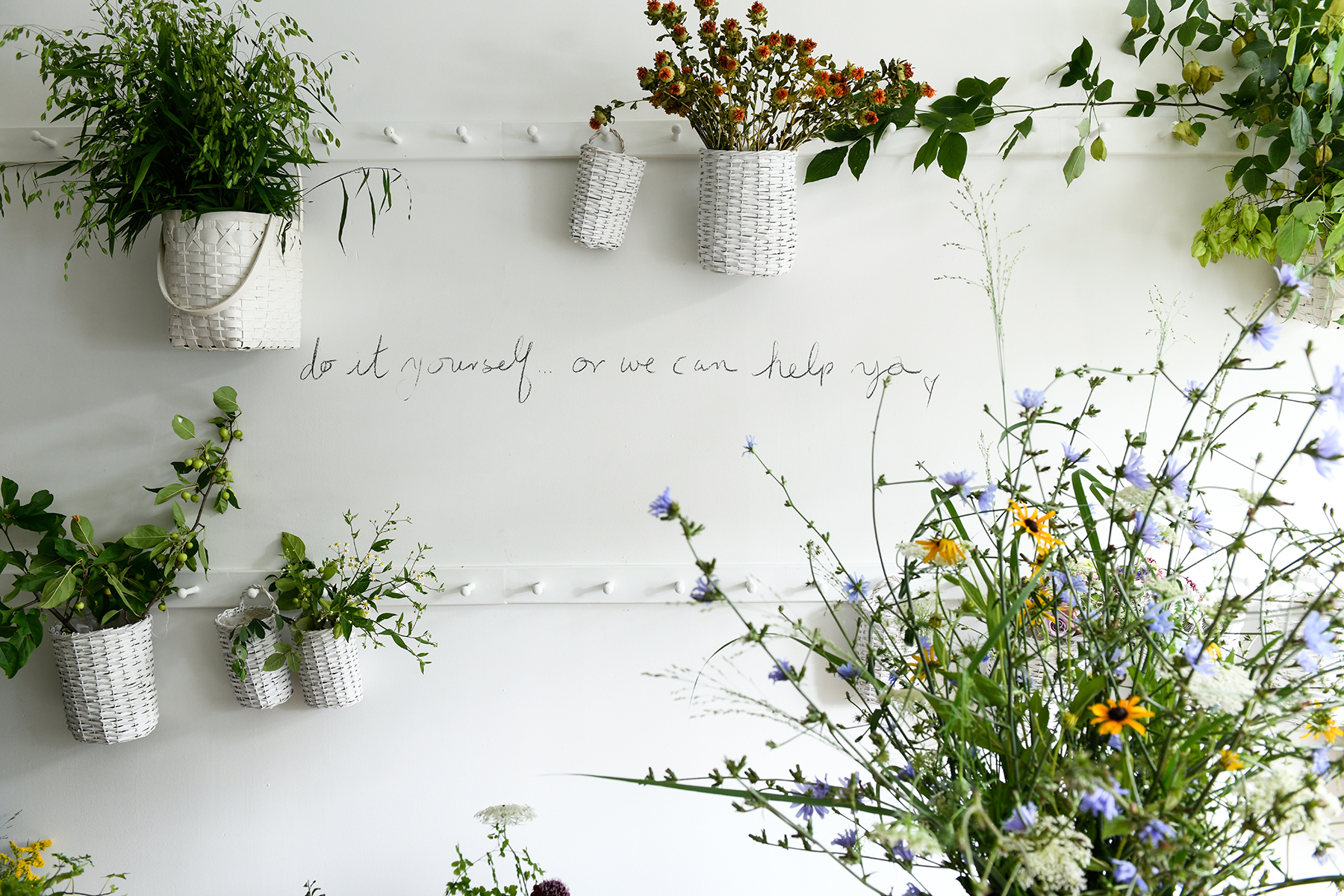 Peg rail holding baskets of flowers