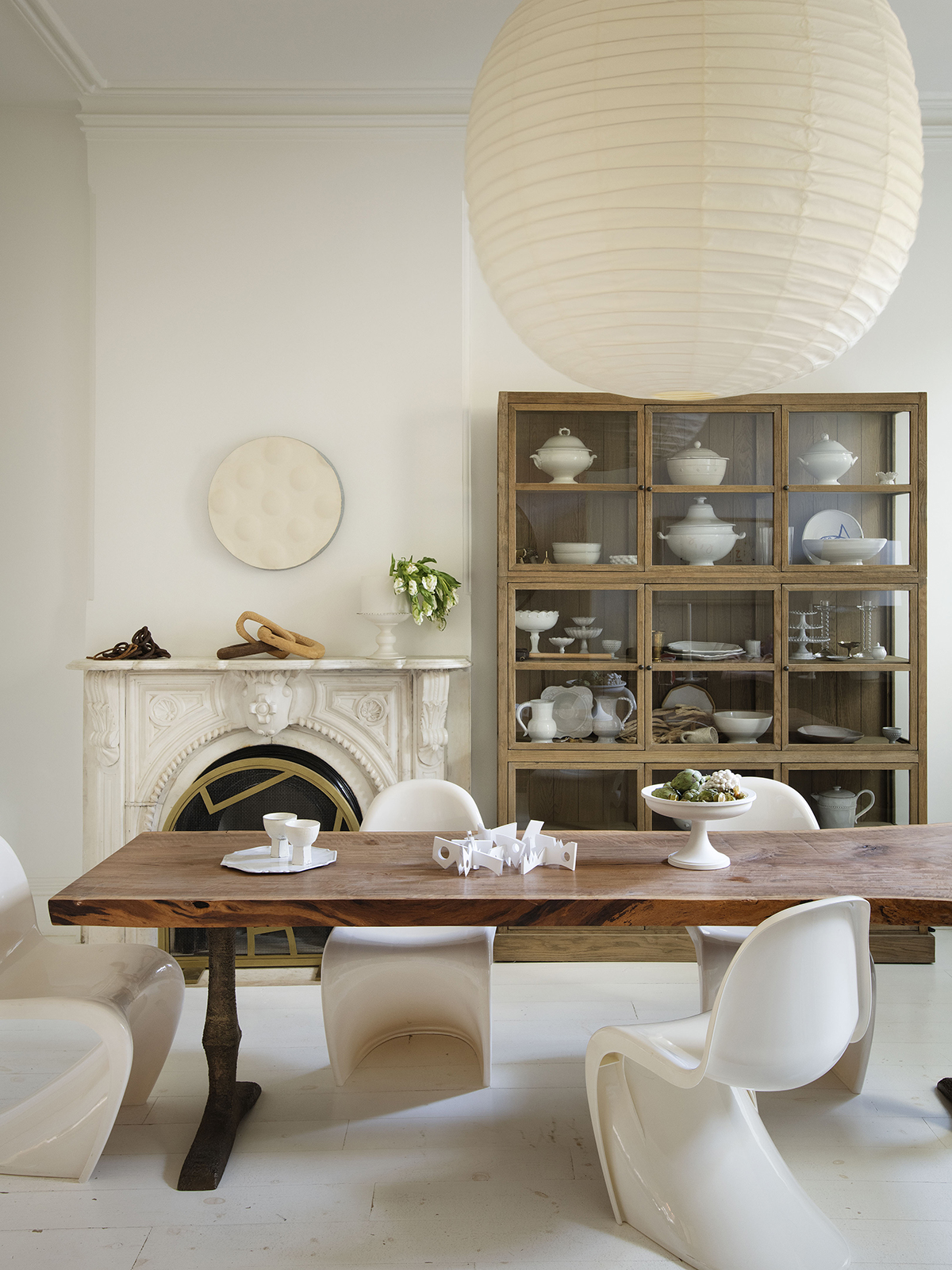 White dining room with wooden table and fireplace