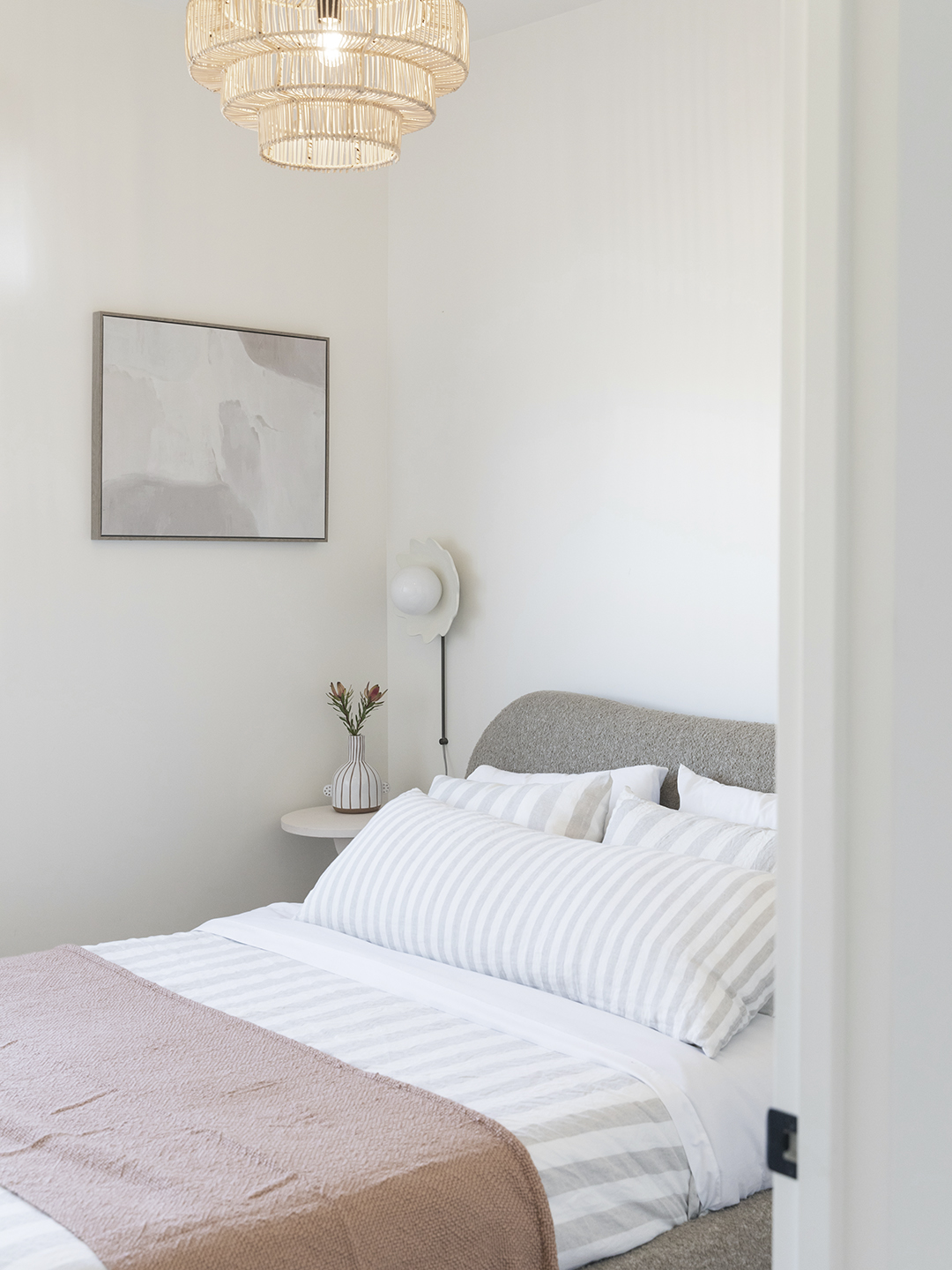 Bedroom with gray headboard and white sheets