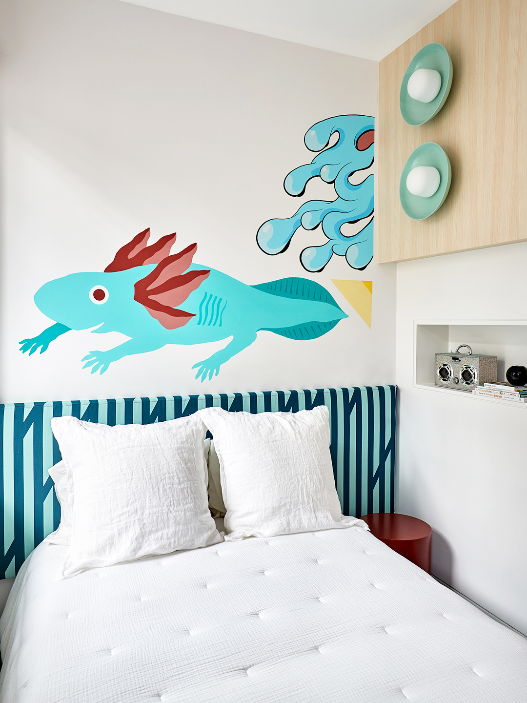 Kids room with striped headboard and iguana wall art.